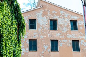 A residential building with a partly damaged orange facade captured during the daytime